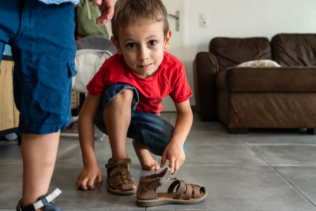 Photo d'un petit garçon enfilant ses chaussures par Simone Photographie