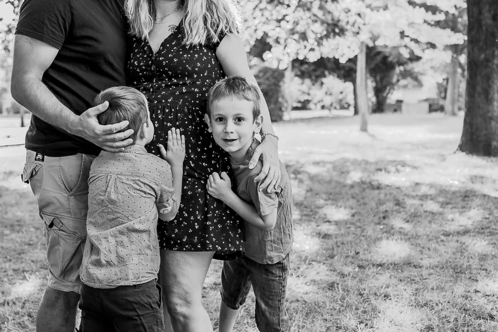 Séance photo de famille Photo en noir et blanc de 2 parents avec leurs jeunes enfants autour d'eux par Simone Photographie