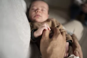 Photo d'un bébé qui tient le pouce de son père par Simone Photographie