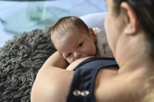 Photo d'un bébé au sein de sa maman dans leur maison par Simone Photographie