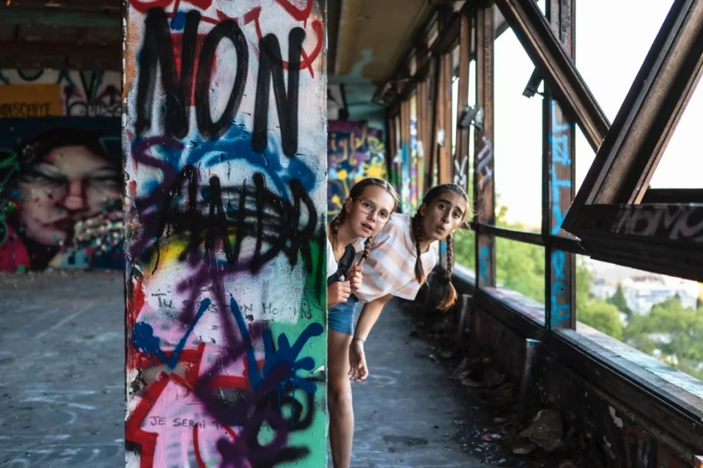 Deux jeunes filles qui jouent dans un batiment désaffecté à Grenoble par Simone Photographie