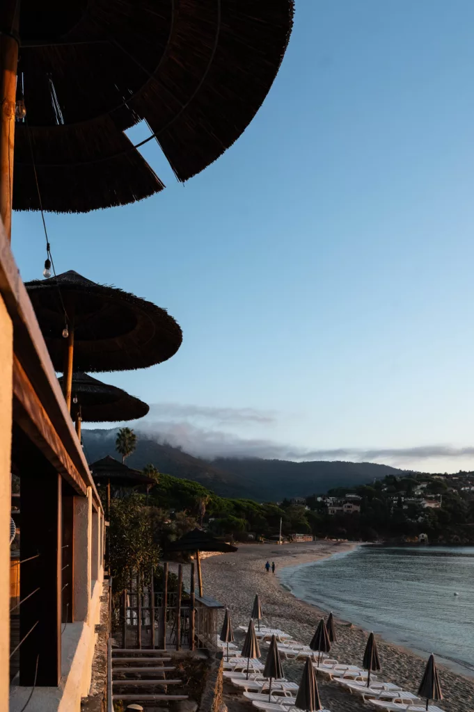 Vue plage depuis terrasse de restaurant, parasols en perspective, création photographe