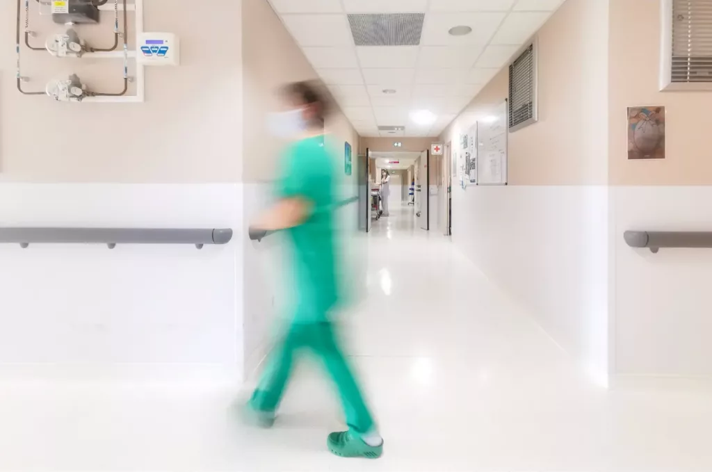 Soignante qui se déplace dans le couloir d'un hôpital pour illustrer la création journal soignante et photographe