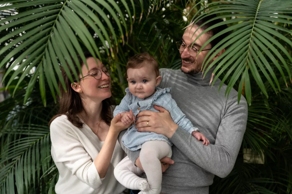 Photo d'un couple avec leur bébé, dans un super spot, serre botanique, jardin des plantes par simone photographe, spot, shooting famille à grenoble